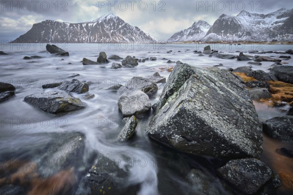 Waves and rocks on coast of Norwegian sea in fjord. Skagsanden beach, Flakstad, Lofoten islands, Norway. Long exposure motion blur