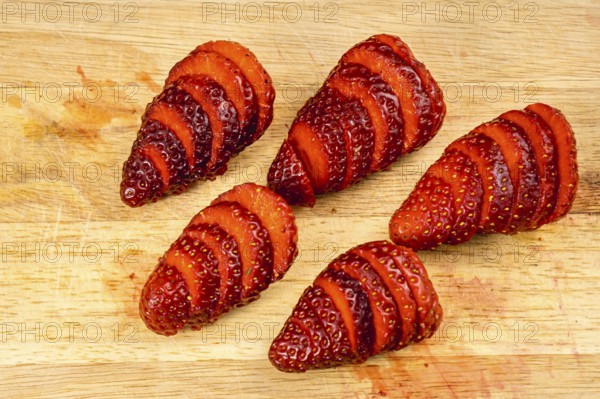 Natural strawberries cut slices on a wood