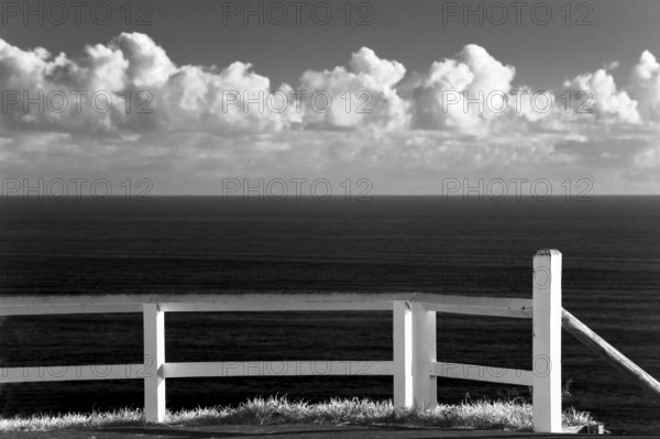 White fence, black and white, with cloudy sky, lovely, puristic, empty, dream, journey, holiday, symbol, on the coast of Byron Bay, Australia, Oceania