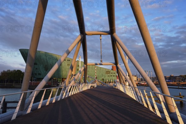 AMSTERDAM, NETHERLANDS, MAY 9, 2017: NEMO Science museum and Mr. J. van der Veldebrug bridge. It is the largest science center in Netherlands with over 500000 visitors per year