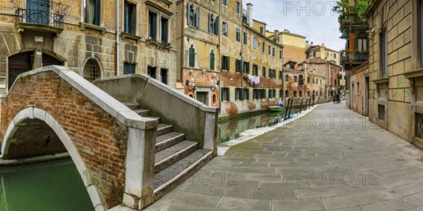 Arched bridge over the old town canal, alley with old couple, Venice, Veneto, Italy, Europe