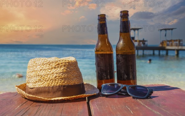 Two beers, sunglasses and a hat on West End beach on Roatan Island. Honduras