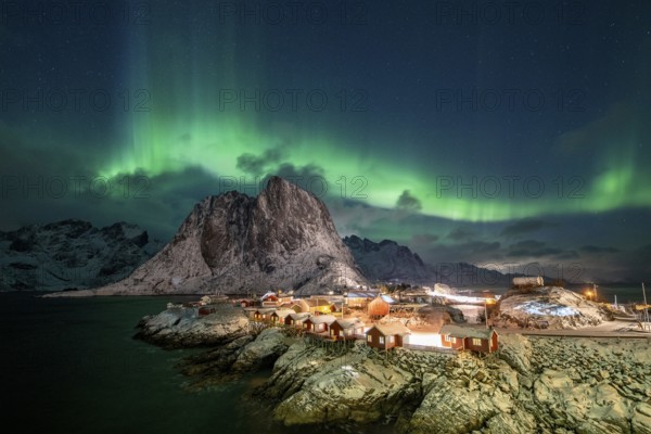Northern Lights (Aurora Borealis) over Rorbuer Huts of Hamnoy, snowy mountains behind, Hamnøy, Reine, Moskenesøya, Lofoten, Norway, Europe