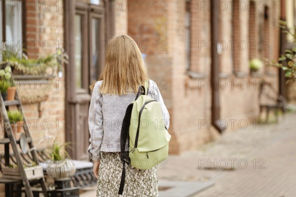 Cute tourist woman in old town, back view