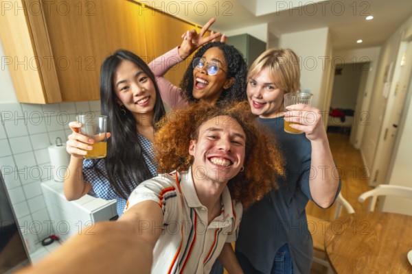 Group of cheerful multi ethnic friends taking a selfie while enjoying glasses of juice together in a modern kitchen
