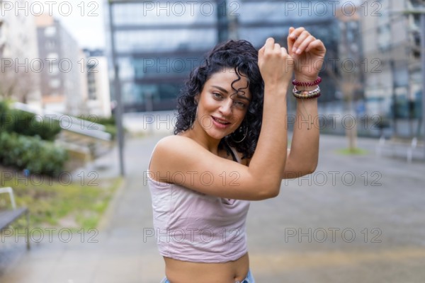 Carefree young woman dancing in an urban setting, enjoying the music and expressing herself through movement