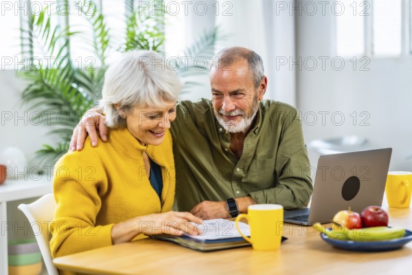 Senior man supporting his wife while doing household finances using laptop and notes