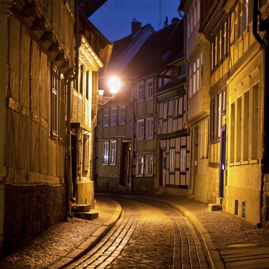 Half-timbered houses in a narrow street with cobblestones, Old Town in the evening, World Heritage City of Quedlinburg, Saxony-Anhalt, Germany, Europe