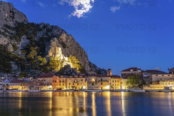The old town centre of Omis on the river Cetina with the ruins of the Mirabella fortress or Peovica at dusk, Croatia, Europe