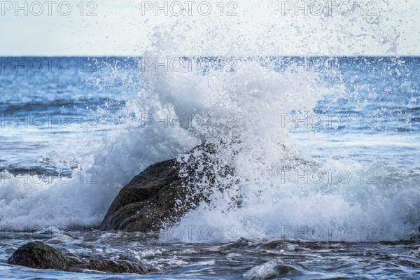 Rocks and sea on the beach of Playa del Inglés. Splashing spray from a wave. Valle Gran Rey, La Gomera, Canary Islands, Spain, Europe
