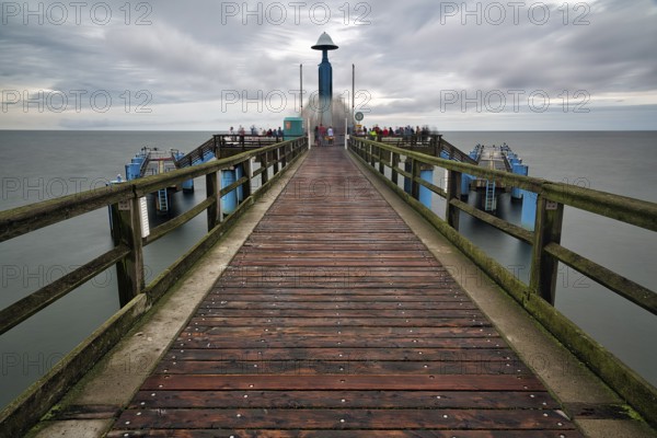 Sellin pier with tourists in front of diving gondola, rainy weather on the Baltic Sea, long exposure, Baltic resort Sellin, Rügen Island, Mecklenburg-Western Pomerania, Germany, Europe