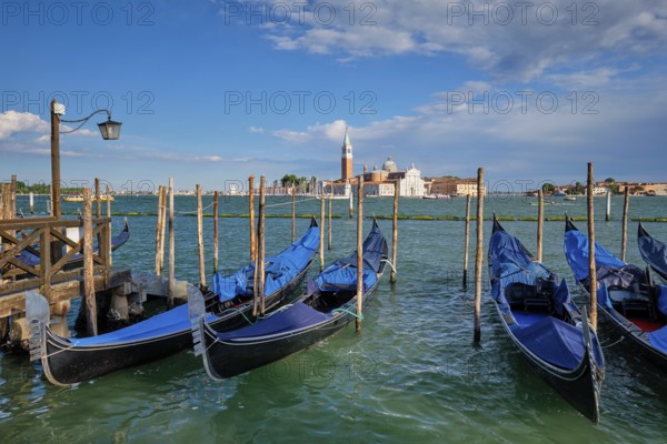 Gondolas and in lagoon of Venice by Saint Mark (San Marco) square with San Giorgio di Maggiore church in background in Venice, Italy, Europe