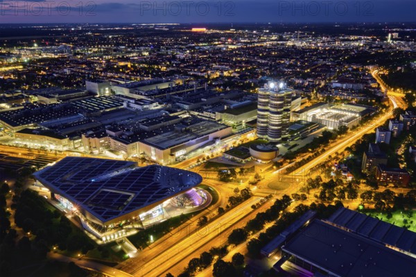 MUNICH, GERMANY, JULY 08, 2018: Aerial view of BMW Museum and BWM Welt and factory and Munich from Olympic Tower illuminated at night. BMW is a famous German luxury car automaker