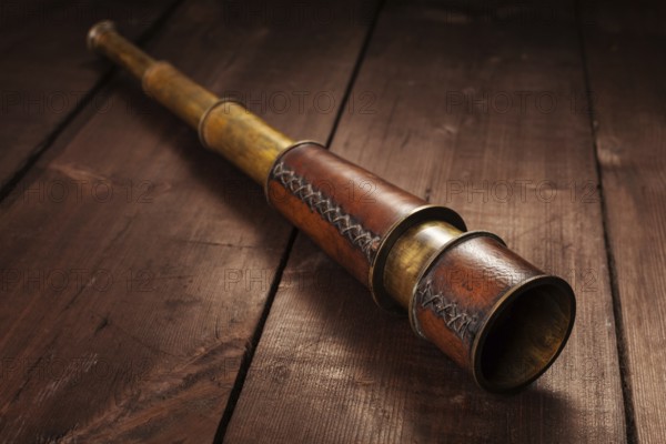 Vintage retro spyglass on wooden background