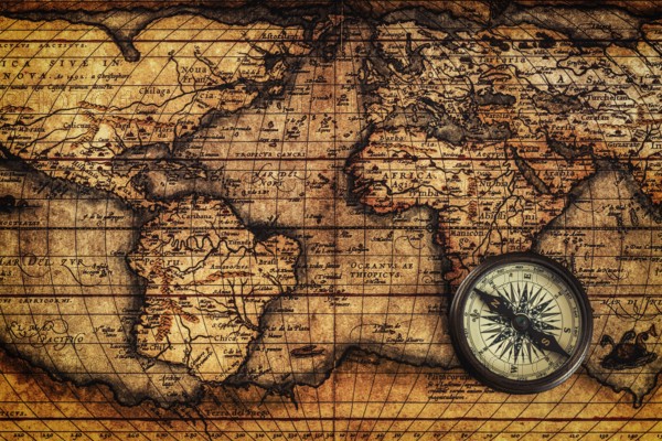 Travel geography navigation concept background, old vintage retro compass on ancient world map