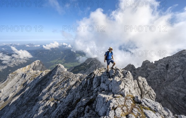 Mountaineer on a rocky narrow mountain path with mountain panorama, mountain tour to the summit of the Hochkalter, Hochkalter crossing, Berchtesgaden Alps, Bavaria, Germany, Europe