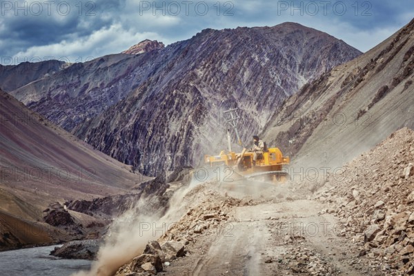 LADAKH, INDIA, SEPTEMBER 10, 2011: Bulldozer cleaning road after landslide in Himalayas. Ladakh, Jammu and Kashmir, India, Asia