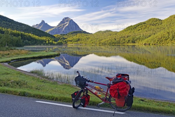 Packed touring bike in front of mountain lake and steep mountains, no cars, bicycle trip, FV !7, Kystriksveien, Nordland, Norway, Europe