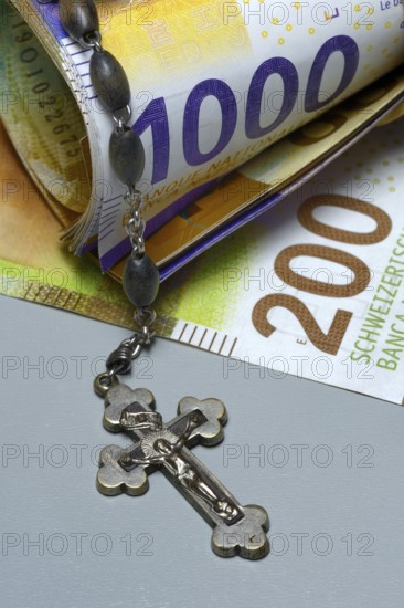 Crucifix and banknotes, Swiss francs, church and money