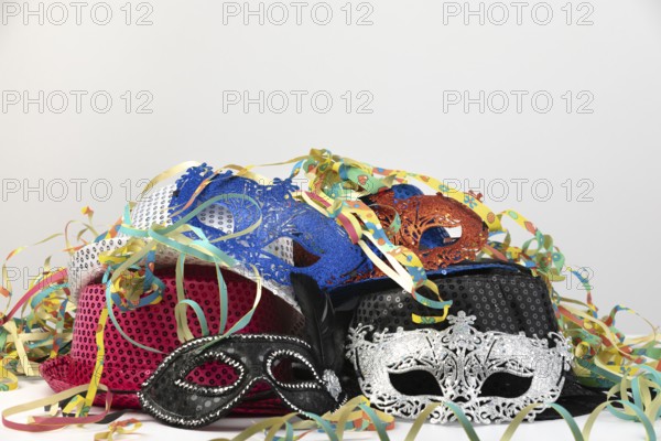 Various carnival masks and hats, surrounded by colourful streamers, carnival