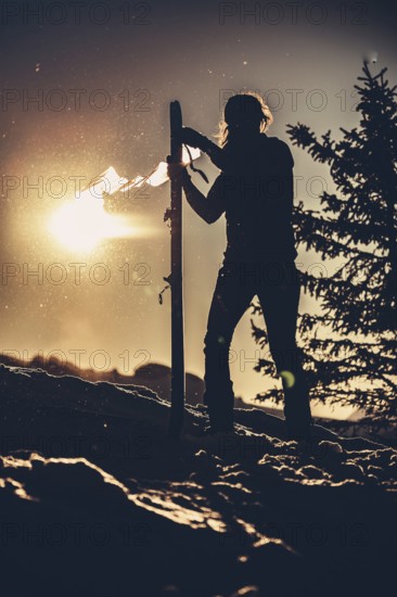 A woman's ski tour at sunrise on the Tegelberg in the Allgäu in the Ammergebirge, Bavaria, Germany, Europe