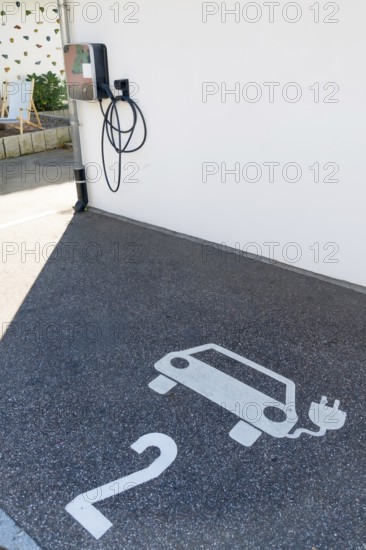 A parking lot with a charging station for electric cars. The parking lot has a white number 2 on the ground