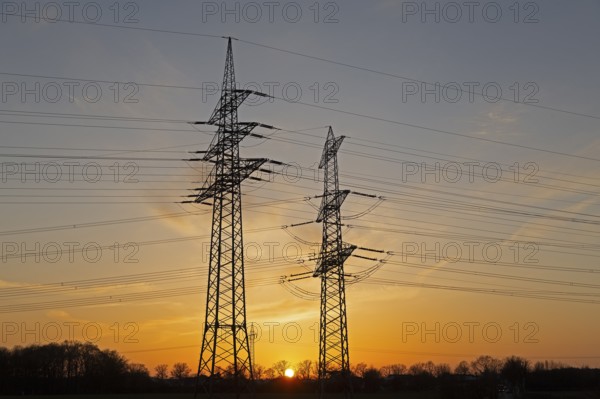 Sunset behind high-voltage pylons, Häcklingen, Lüneburg, Lower Saxony, Germany, Europe