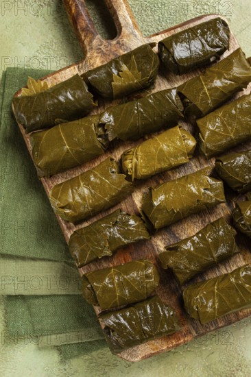Dolma, minced meat with rice, in grape leaves, minced meat rolls, on a chopping board, top view, no people