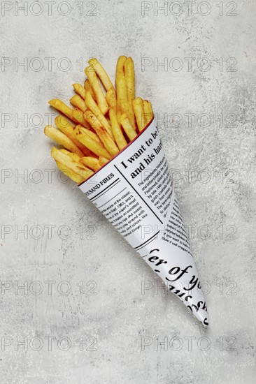 Fried French fries in a paper bag, on an abstract background, without people, in a rustic style, in a cone package, newspaper, a bag from the newspaper