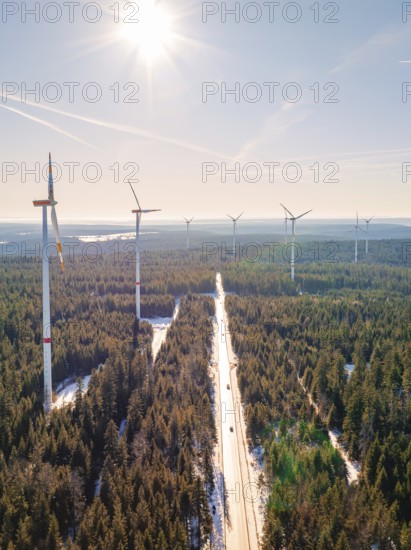 Wind turbines along a snow-covered road in a forest, Seewald, Black Forest, Germany, Europe