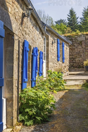 Narrow alley in an old idyllic French villages with picturesque stone houses and blue window shutters, Locronan, Bretagne, France, Europe