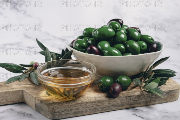Chalkidiki olives, classic Greek green olives, in a bowl on a cutting board, top view, without people