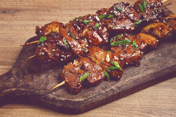 Yakitori chicken kebab, on skewers, with green onions and sesame seeds, top view, without people