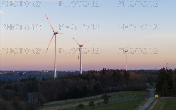 Wind turbines on a road at dusk with forested background, Rems Valley, Baden-Württemberg, Germany, Europe
