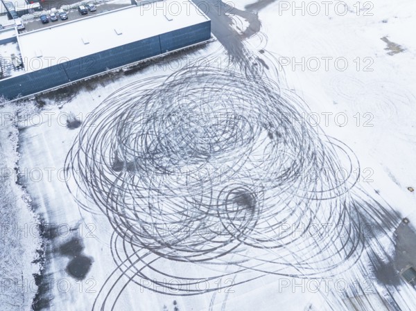 Tyre tracks form large circles on a snow-covered surface as seen from the air, Nagold, Black Forest, Germany, Europe