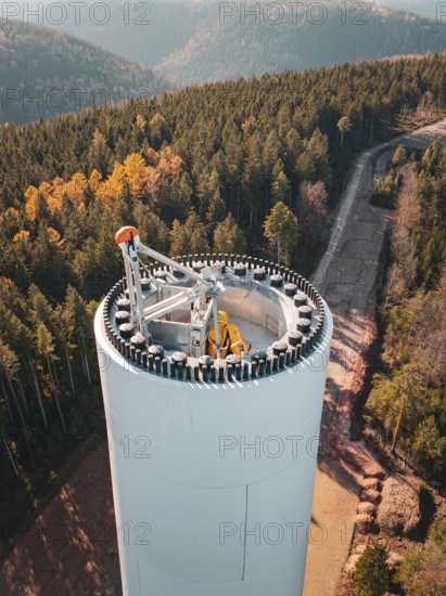 Autumn landscape with a wind turbine under construction, surrounded by colourful forest and mountainous terrain, wind turbine construction, Calmbach, Black Forest, Germany, Europe