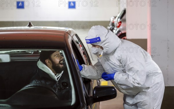 Cologne, North Rhine-Westphalia, Germany - Covid rapid test in a car park, at the Medicare test centre, customers drive up to the drive-in counter for sampling (staged scene)