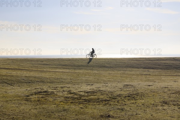 Cyclist on the south beach polder dyke, Norderney, Lower Saxony, Germany, Europe