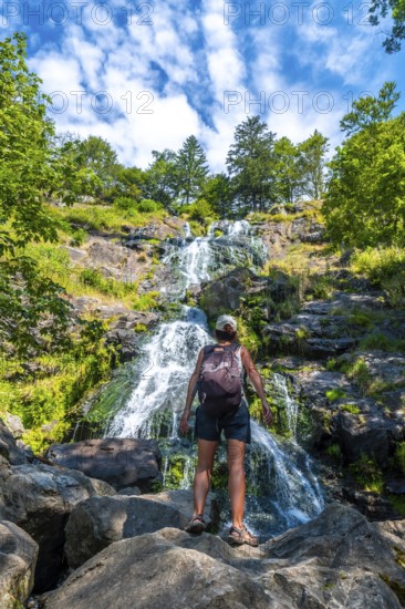 A female backpacker in summer at the Todtnau waterfall in the Black Forest in Germany