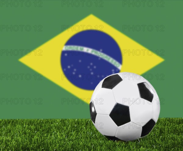 The Brazilian flag and soccer ball on the green grass