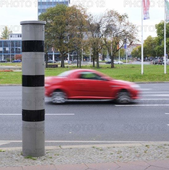 Berlin, Germany, October 13, 2022, speed camera column at Ernst-Reuter-Platz with passing blurred red car, Europe