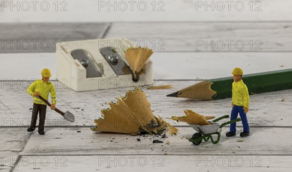 Little figures from little world cleaning up the mess of the mess of the pencil sharpener