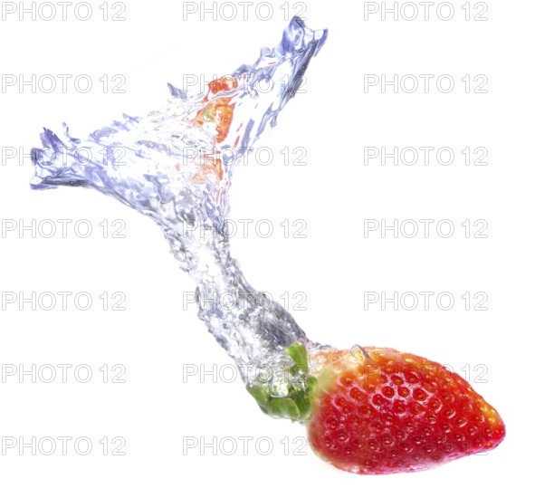 Strawberry dropped on a water tank with a splash of water behind it