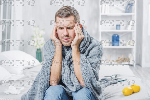Young man suffering from cold having headache