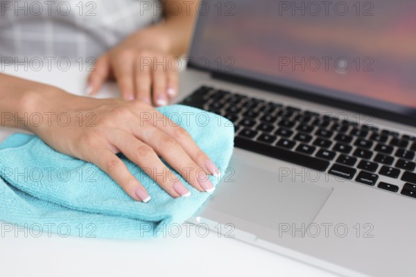 Woman hand cleaning laptop home
