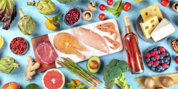 Food, overhead panorama on a blue background. Meat, fish, seafood, poultry, wine, cheese, mushrooms, pasta, nuts, fruits and vegetables, a variety of healthy organic products