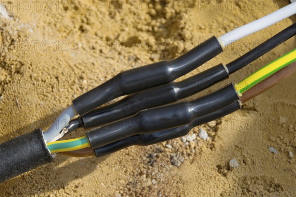Connected power cables for house connection in the ground with heat-shrink tubing