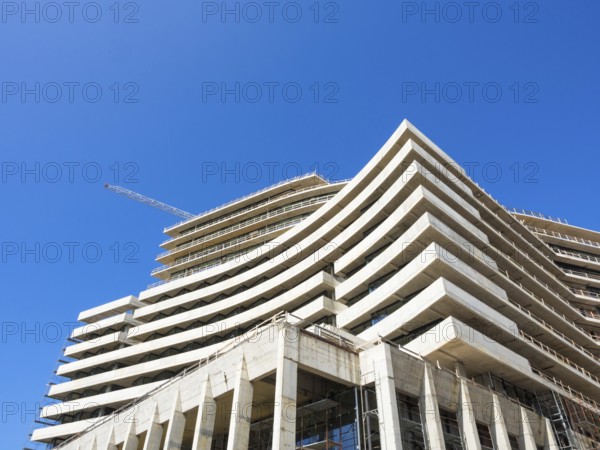 Crane and building construction site against blue sky