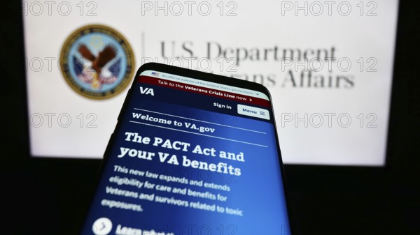 Stuttgart, Germany, 10-30-2023: Smartphone with website of United States Department of Veterans Affairs (VA) in front of seal. Focus on top-left of phone display, Europe