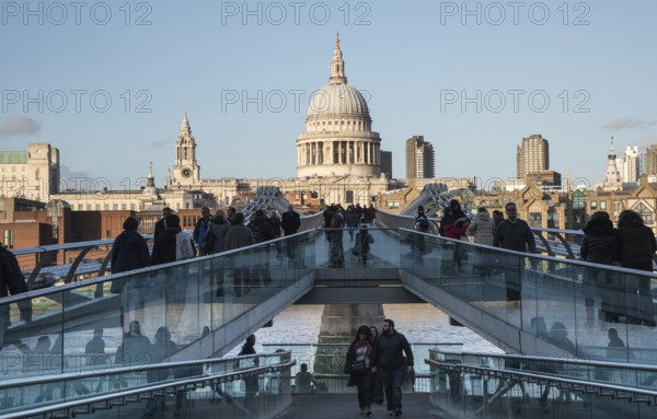 London, United Kingdom, December 8 2015: People walking at the Millennium bridge, officially known as the London Millennium Footbridge crossing river Thames Saint Paul Cathedral at a distance, Europe